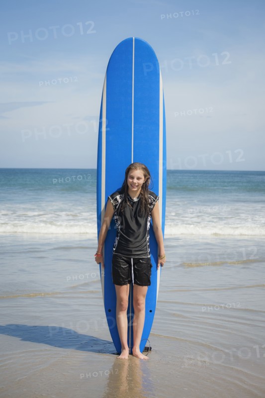 Caucasian girl holding paddleboard on beach