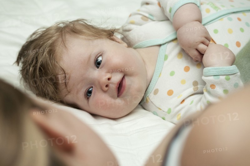 Caucasian mother and daughter laying on bed