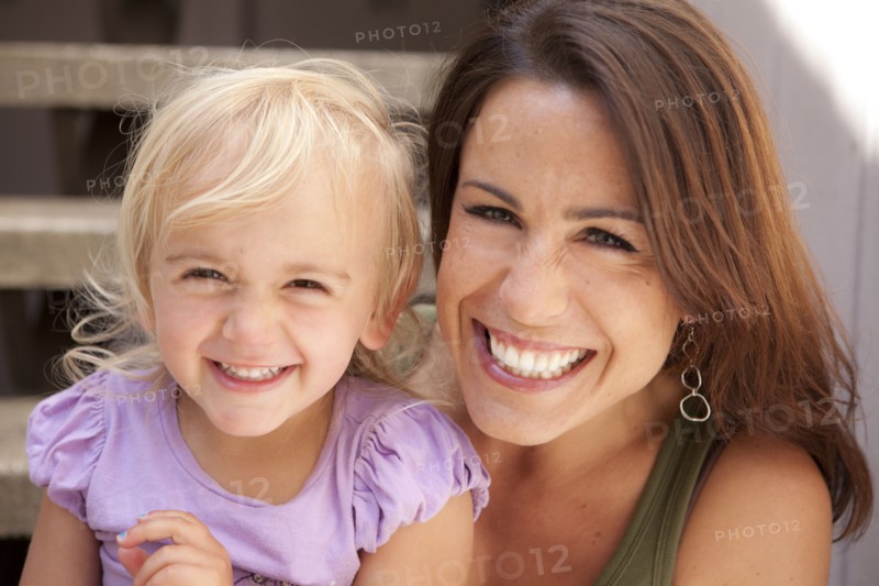Caucasian mother and daughter smiling on steps