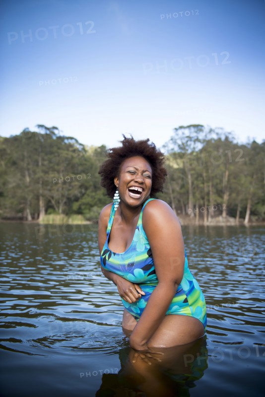 African American woman standing in rural lake