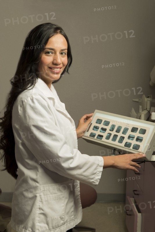 Indian dentist examining x-rays in office