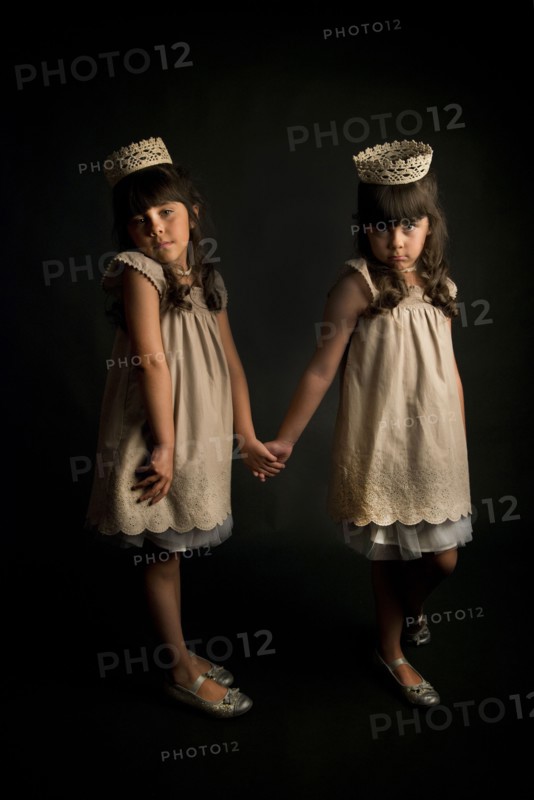 Twin girls wearing crowns and princess costumes