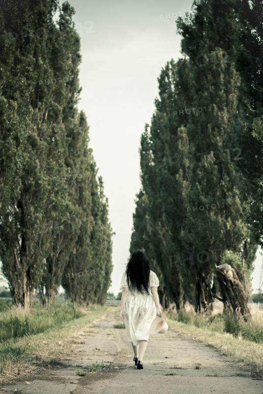 Woman walking on dirt road
