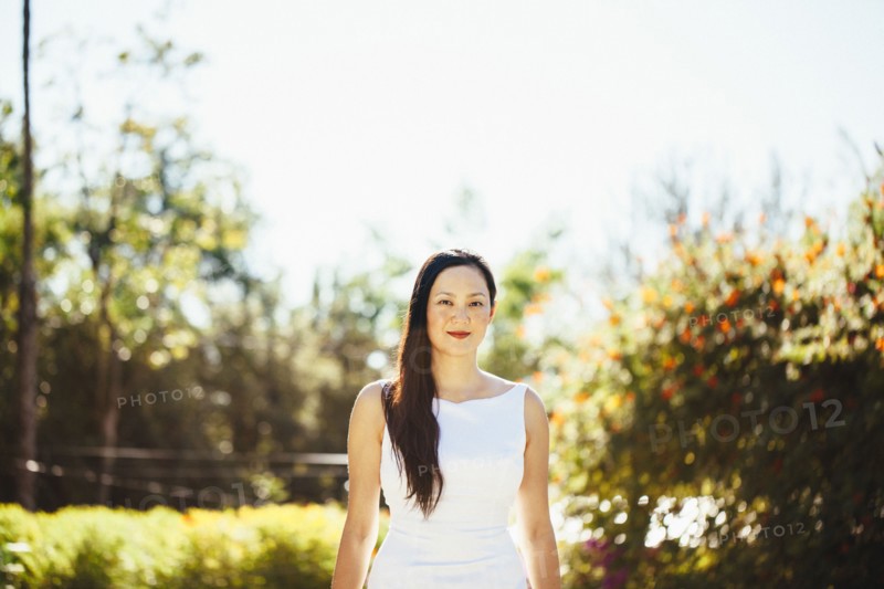 Korean bride smiling near trees