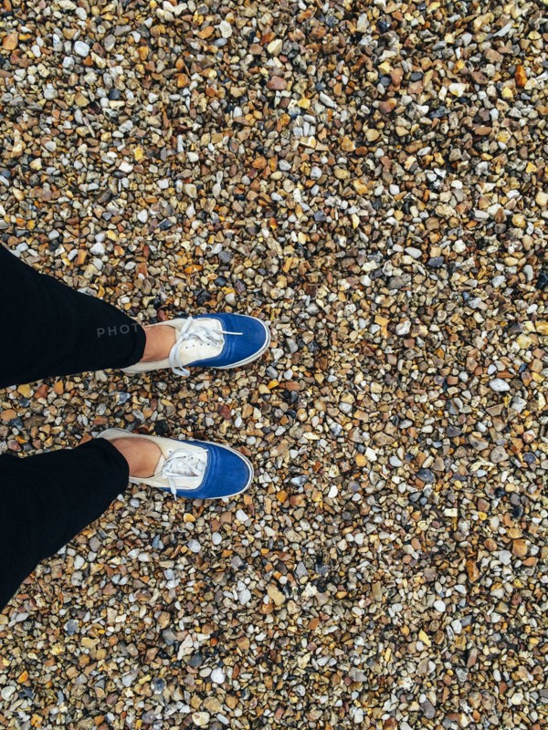 Caucasian woman wearing sneakers in pebbles