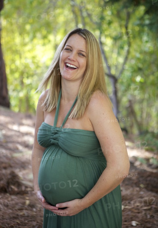 Laughing pregnant woman holding belly