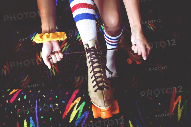 High angle view of woman lacing up roller-skates