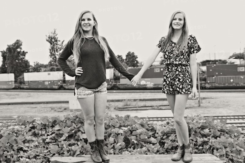 Teenage girls holding hands in train yard
