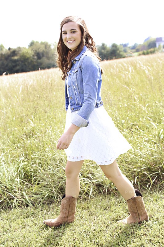 Woman walking in tall grass in field