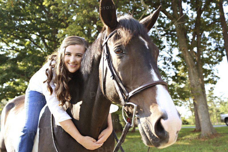 Woman hugging horse in rural field