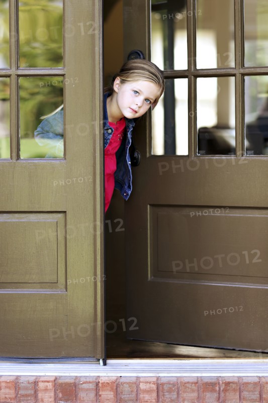 Curious girl standing in doorway