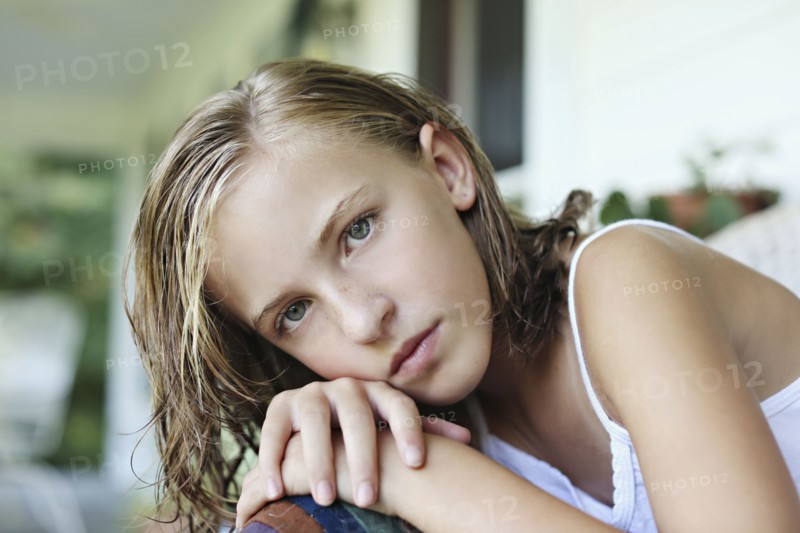 Close up of serious girl leaning in armchair