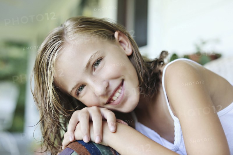 Close up of smiling girl leaning in armchair