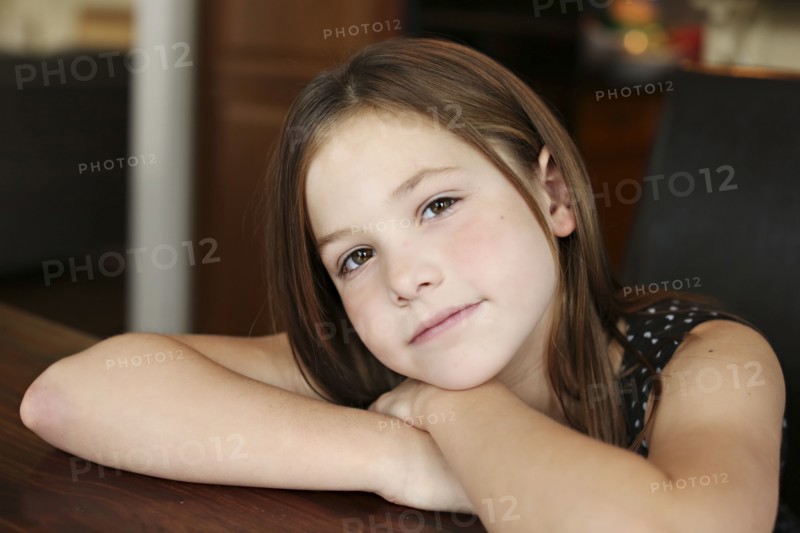 Close up of serious girl resting chin on hand