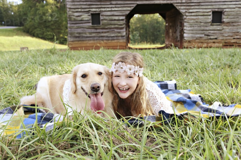 Caucasian girl laying on blanket with dog