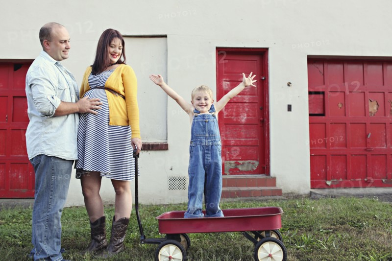Parents watching son cheering in toy wagon