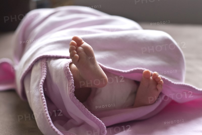 Close up of feet of baby girl in blanket