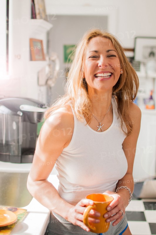 Mixed race woman drinking coffee in kitchen