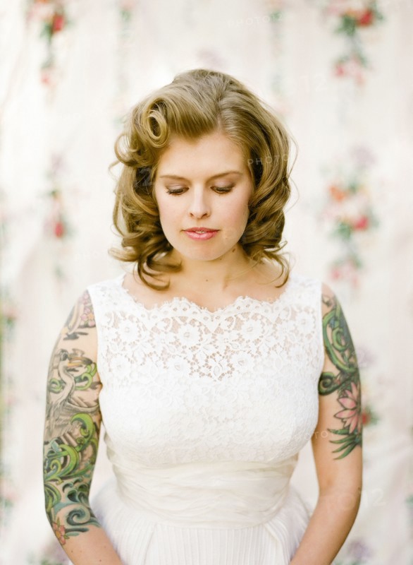 Close up of bride with tattoos wearing wedding dress
