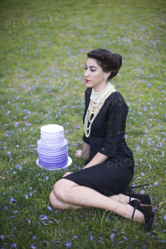 Woman sitting with cake in rural field