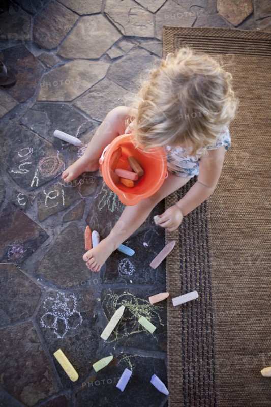 High angle view of girl drawing with chalk on tile
