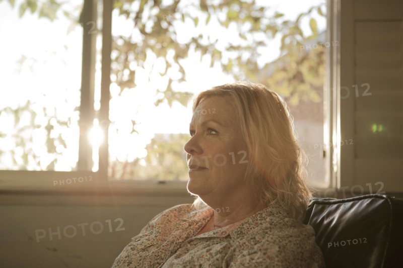 Close up of older woman sitting near window