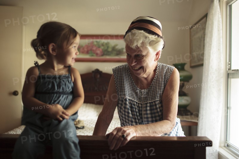 Grandmother and granddaughter playing on bed