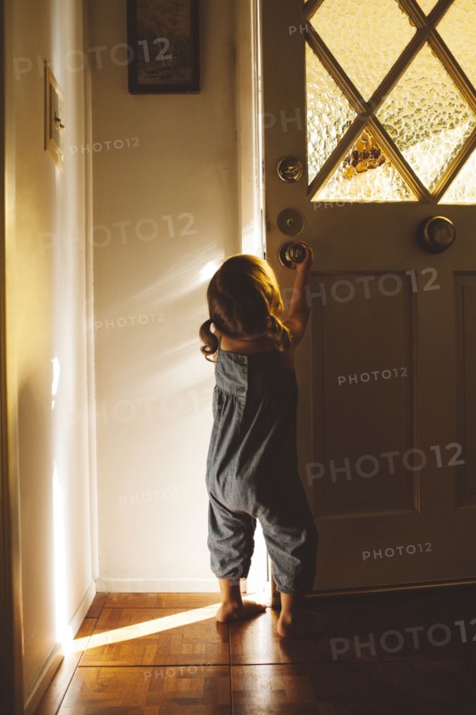Hispanic preschooler girl opening front door