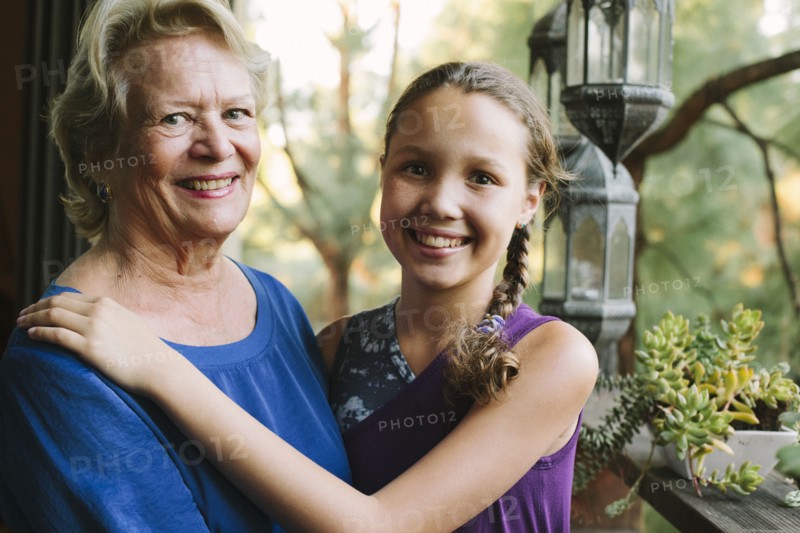 Grandmother and granddaughter smiling on porch