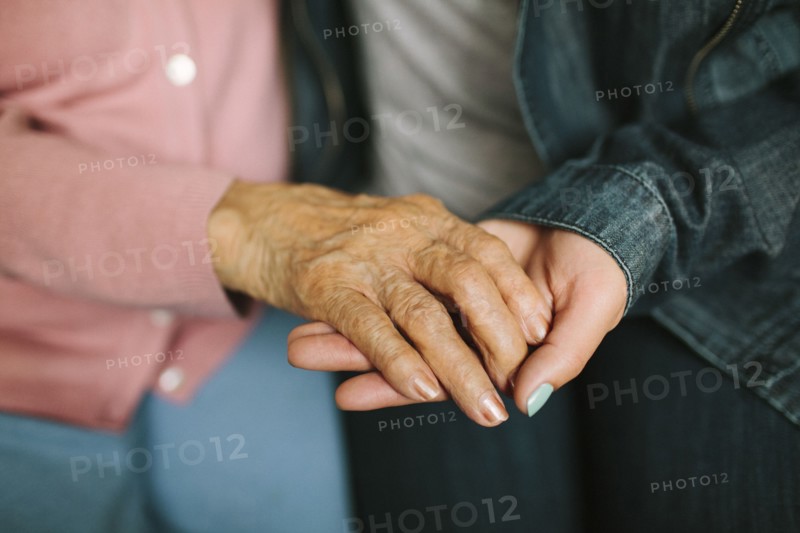 Close up of grandmother and granddaughter holding hands