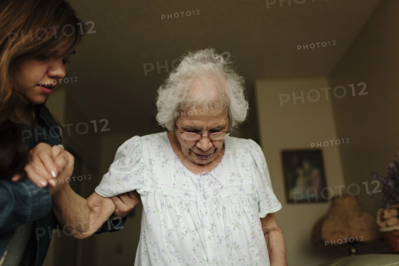 Granddaughter helping grandmother stand