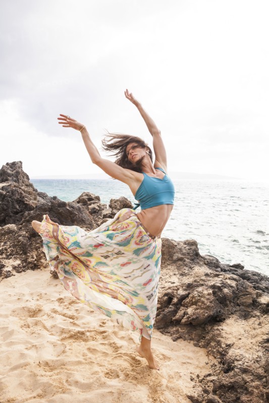 Woman dancing on rocky beach