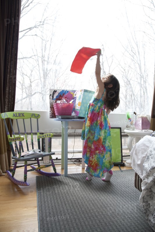 Caucasian girl playing in bedroom
