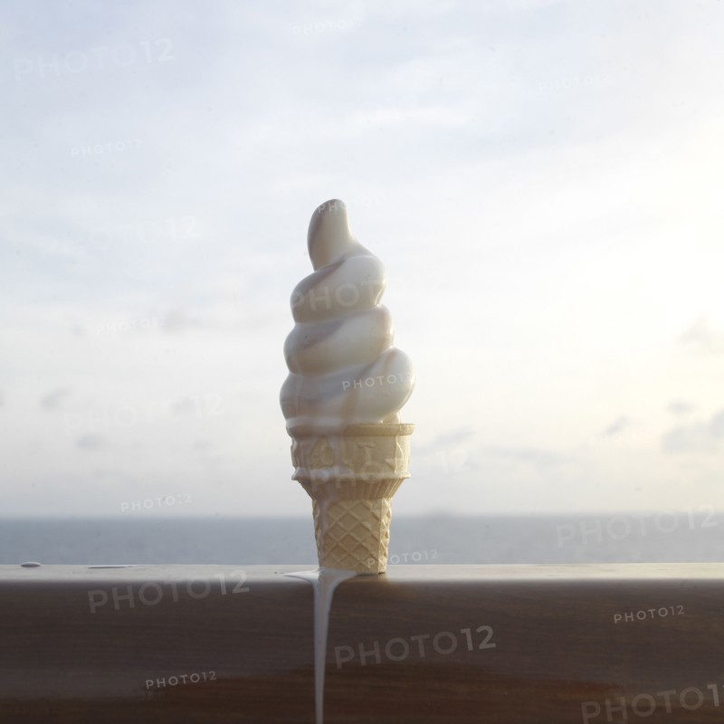Close up of melting ice cream cone on banister