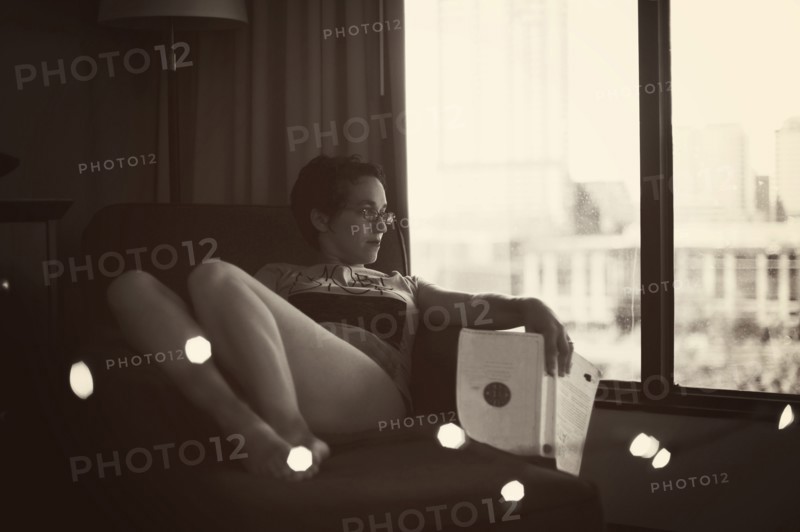 Caucasian woman reading in armchair