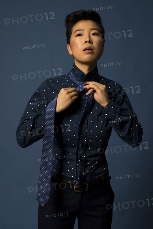 Androgynous woman tying tie
