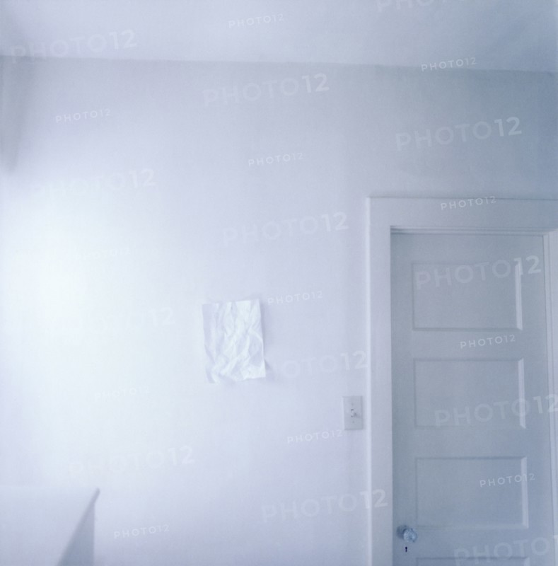 Wrinkled paper on empty white wall