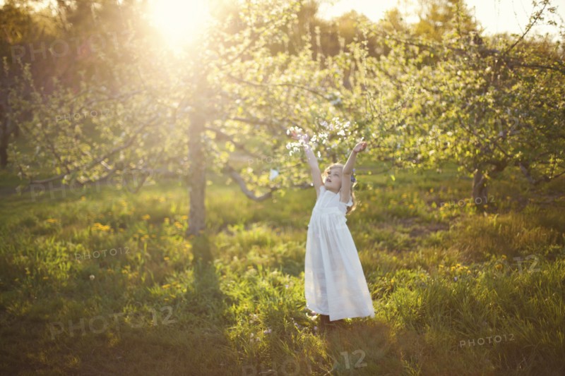 Caucasian girl tossing flower petals outdoors