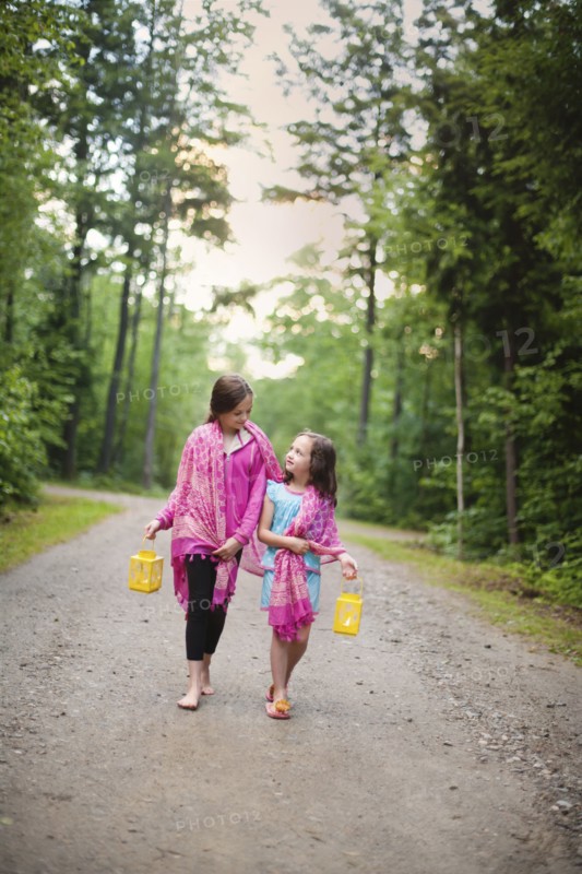 Caucasian sisters walking on dirt road