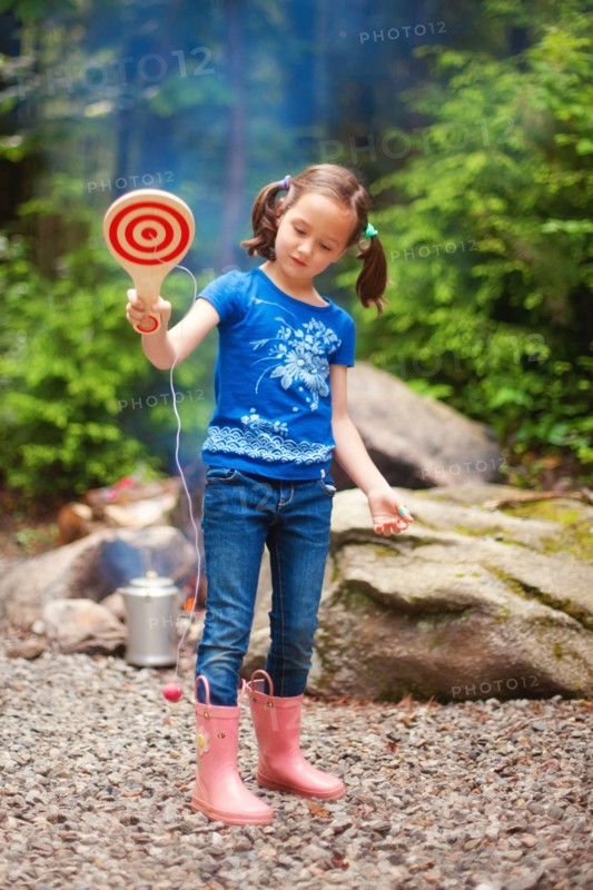 Caucasian girl playing with toy in forest