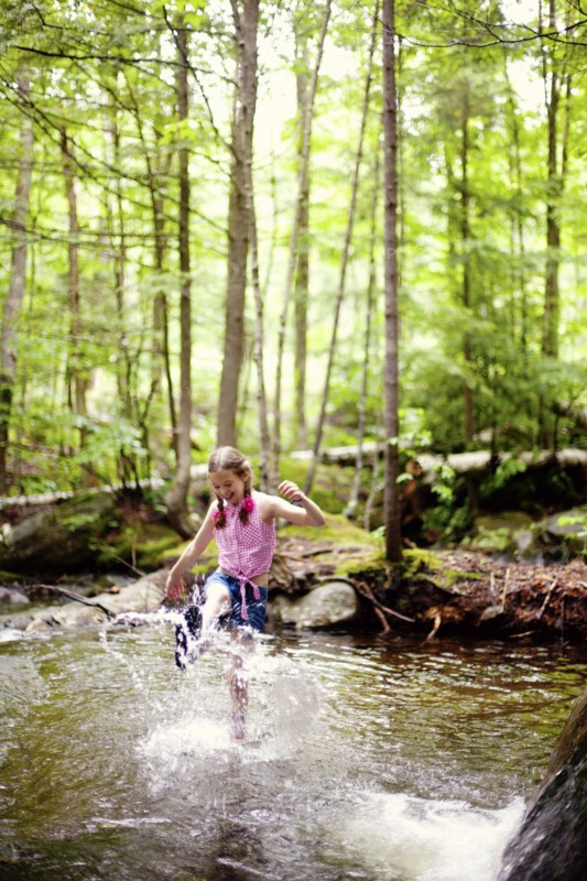 Caucasian girl splashing in river