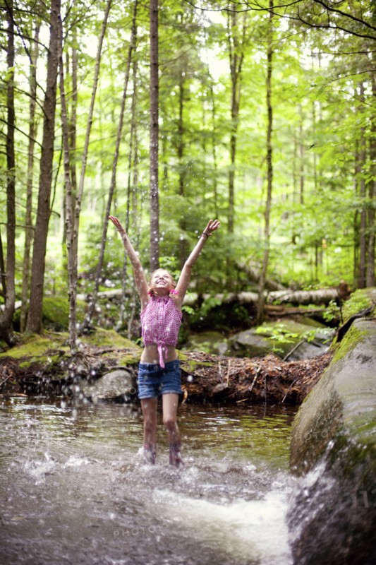 Caucasian girl splashing in river