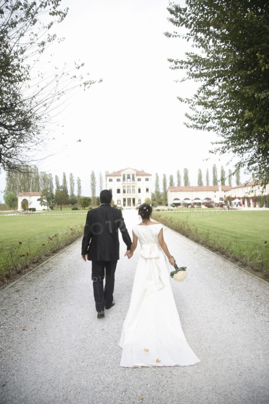 Caucasian bride and groom walking on gravel path