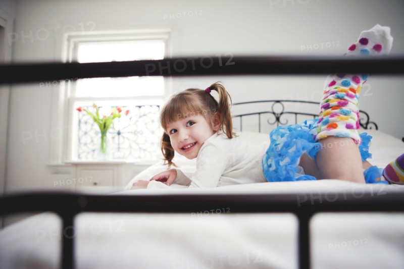 Smiling girl playing on bed