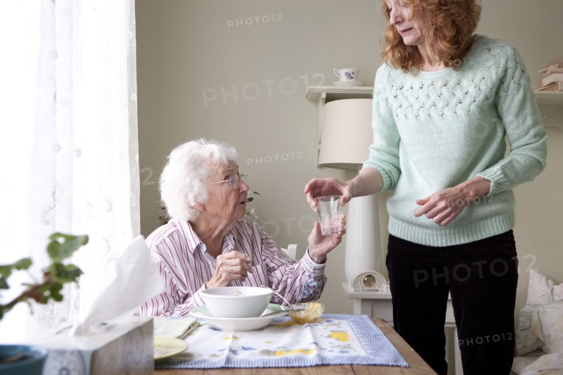Woman giving mother glass of water