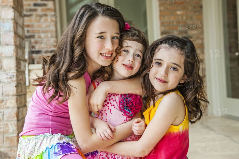 Playful sisters hugging outdoors