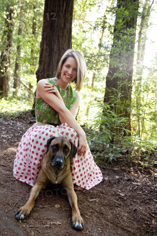 Mixed race woman and dog in forest