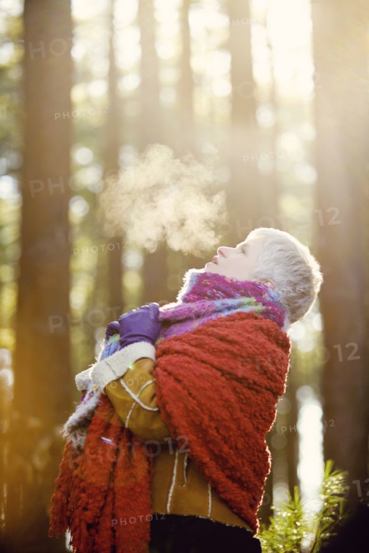 Older Caucasian woman breathing steam outdoors