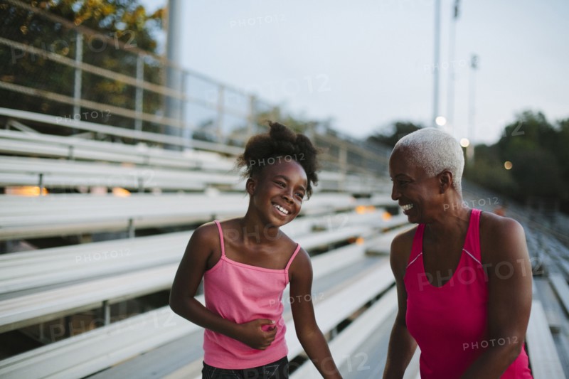 Grandmother and granddaughter standing on bleachers
