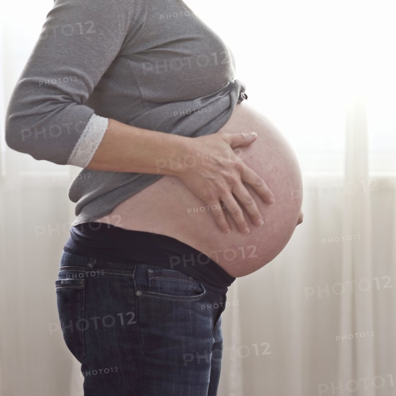 Pregnant Caucasian woman caressing stomach